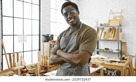 Confident african american male carpenter with arms crossed in a well-equipped workshop - Powered by Shutterstock