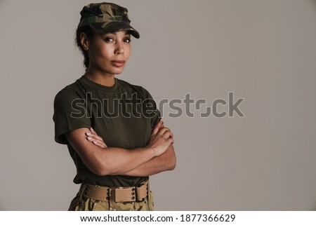 Confident african american soldier woman posing with arms crossed isolated over grey wall
