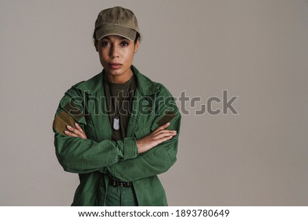 Confident african american soldier woman posing with arms crossed isolated over grey wall