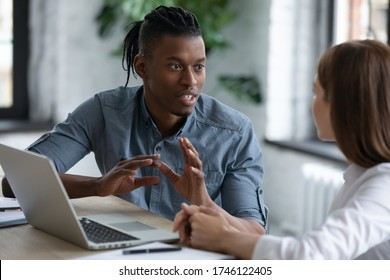 Confident African American team leader mentor teaching new employee, giving instructions to businesswoman, diverse colleagues sharing ideas, working on project together, discussing strategy - Shutterstock ID 1746122405