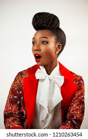 Confident African business woman  wearing an African print suit and heels with a sophisticated hair with a surprised look on her face