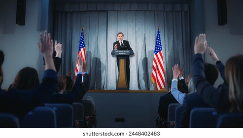 Confident American republican politician delivers successful speech to supporters at government election rally. New president of USA gives interview for media. Backdrop with American flags. Zoom out. - Powered by Shutterstock