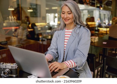 Confident Asian businesswoman networking in coffee shop - Shutterstock ID 2163960209
