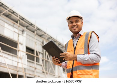 Confident Asian Engineer Man Using Tablet For Checking And Maintenance To Inspection At Modern Home Building Construction. Architect Working With White Safety Helmet In Construction Site