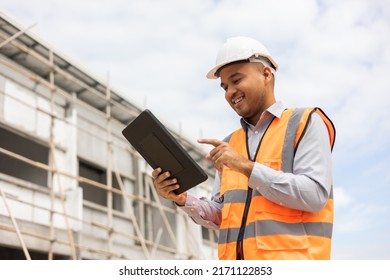 Confident asian engineer man Using tablet for checking and maintenance to inspection at modern home building construction. Architect working with white safety helmet in construction site - Powered by Shutterstock