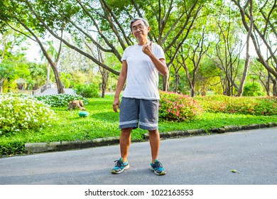Confident Asian Senior male posing with arms crossed and smiling at park outdoor background. - Shutterstock ID 1022163553