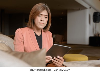 Confident Asian transgender non binary person in business attire at stylish indoor cafe restaurant