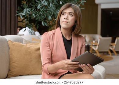 Confident Asian transgender non binary person in business attire at stylish indoor cafe restaurant