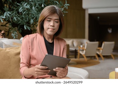 Confident Asian transgender non binary person in business attire at stylish indoor cafe restaurant - Powered by Shutterstock - Get 15% off with code: PIKWIZARD15
