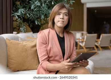 Confident Asian transgender non binary person in business attire at stylish indoor cafe restaurant