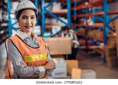 Zuversichtliche asiatische Eigentümerin, die im Warenlager steht und ihren Arm überquert und die Kontrolle der Containerlager des Frachtschiffs für Einfuhr und Ausfuhr auf Kontrolle überprüft