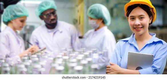 Confident Asian woman owner standing at goods warehouse store and check for control juice industrial process at factory. Teamwork at production line successful concept.