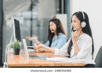 Confident asian young woman call center operator wearing headphones with a microphone - Powered by Shutterstock