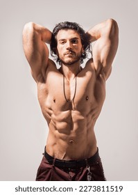 Confident, attractive shirtless muscular young man with open vest on - Shutterstock ID 2273811519