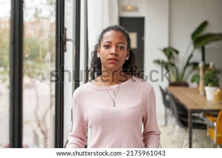 Confident beautiful African woman professional with serious face standing at home in office looking at camera. Confident entrepreneur lady posing alone, head shot close up view portrait