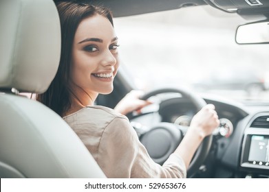 Confident and beautiful. Rear view of attractive young woman in casual wear looking over her shoulder while driving a car  - Shutterstock ID 529653676