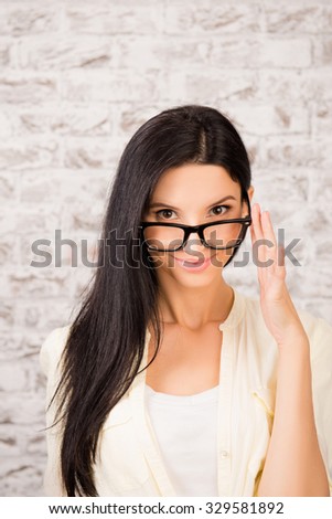 Confident beautiful young woman holding her glasses