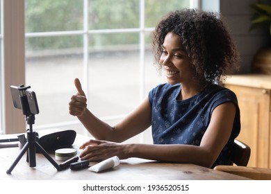 Confident black female vlogger beauty expert shoot promo video content on cellphone webcam recommend cosmetic brand. Young biracial lady professional blogger filming visage master class show thumb up - Powered by Shutterstock