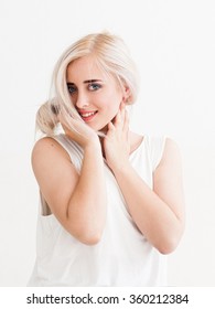 Confident Blonde With Big Blue Eyes, Bright Eyebrows, Smiles, Flirting And Looking At The Camera. Studio Photo On White Background.