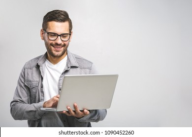 Confident business expert. Confident young handsome man in shirt holding laptop and smiling while standing against white background - Powered by Shutterstock