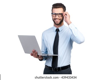 Confident Business Expert. Confident Young Handsome Man In Shirt And Tie Holding Laptop And Smiling While Standing Against White Background