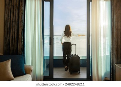 Confident business leader with suitcase solo travel, standing and enjoying large balcony, looking away on tropical paradise beach during sunset time and enjoys her vacation. Colorful sunset over ocean - Powered by Shutterstock