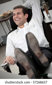 Confident Business Man At The Office With His Feet On The Desk