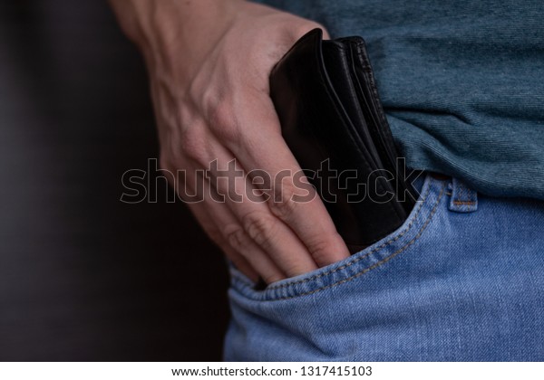 Confident business man safe keeping his wallet in\
the back pocket of his\
pants