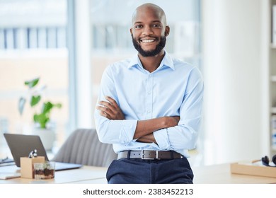 Confident business man standing with arms crossed in an office, looking proud and happy alone at work. Portrait of a smiling, cheerful and professional African male boss working in corporate
