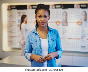 Confident Business Owner In Own Shop With Customers In Background
