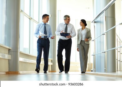 Confident Business Partners Walking Down In Office Building And Discussing Work