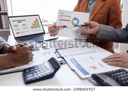Confident business people point to graphs and charts to analyze marketing data graph chart document, balance sheet, account, net profit to plan new sales strategies to increase production capacity.