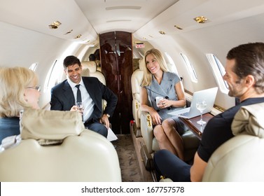 Confident business professionals having drinks on a private jet - Powered by Shutterstock