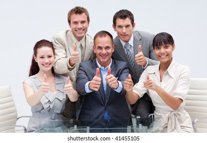 Confident business team with thumbs up in the office