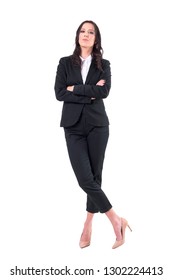 Confident Business Woman In Black Suit With Crossed Arms And Crossed Legs Standing. Full Body Isolated On White Background. 