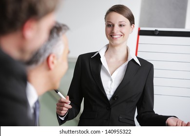 Confident Business Woman Giving A Presentation On Whiteboard