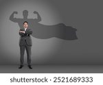 Confident businessman casting shadow of superhero on grey background. Success, power, leadership and determination concepts