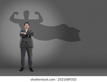 Confident businessman casting shadow of superhero on grey background. Success, power, leadership and determination concepts - Powered by Shutterstock