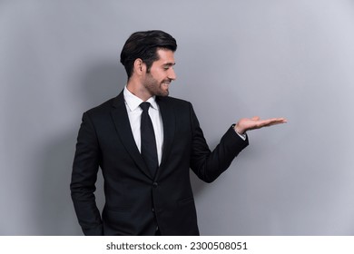 Confident businessman in formal suit making holding hand gesture to indicate promotion or advertising on empty space with excited facial expression and gesture on isolated background. Fervent