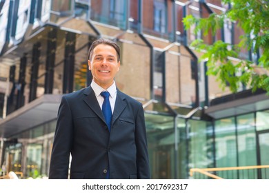 Confident Businessman In Front Of Modern Office Building. Financial Investor Is Walking Outdoor. Banking And Business.