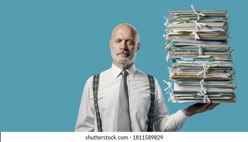 Confident businessman holding a pile of paperwork effortlessly with one hand, easy business administraton concept