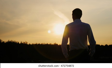 Confident businessman looking forward to the sunset. Well dressed. Concept: hope, dreams, new horizons