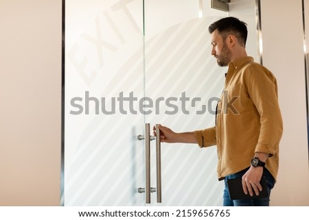 Confident Businessman Opening Glass Door Entering Modern Office Holding Digital Tablet Computer. Job Search And Employment. Successful Business Career Concept