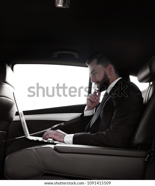 confident businessman sitting on the backseat of a\
prestigious car