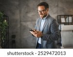 confident businessman take a break from work and use mobile phone and smile in modern office