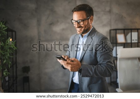 confident businessman take a break from work and use mobile phone and smile in modern office