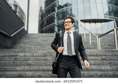 Confident businessman walking downstairs outside modern office building. - Powered by Shutterstock