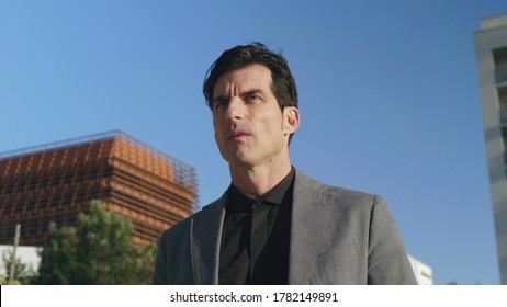 Confident Businessman Walking On Street In Slow Motion. Portrait Of Focused Worker Looking Away Outside. Serious Business Man Going For Work On Urban Street