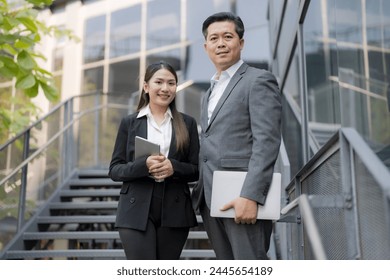 Confident businessmen and businesswoman descending outdoor stairs in a modern urban setting - Powered by Shutterstock