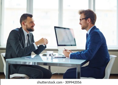 Confident Businessmen Sitting By Table During Consultation